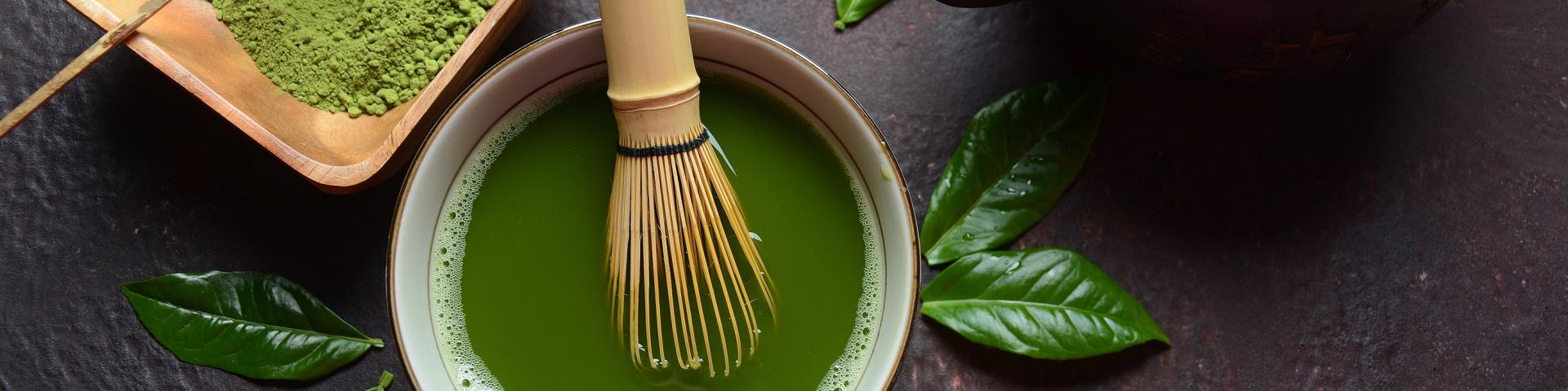 Green matcha tea drink and tea accessories on white background.