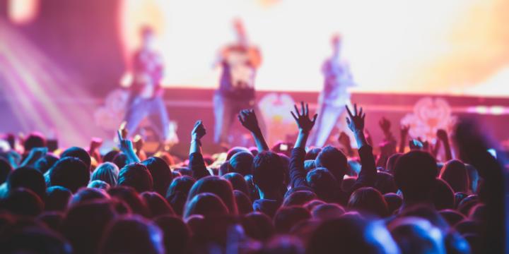 A crowd at a concert with lighting on the performers