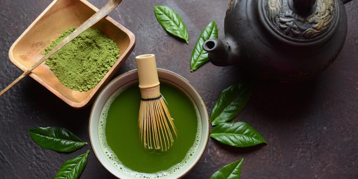 Green matcha tea drink and tea accessories on white background.