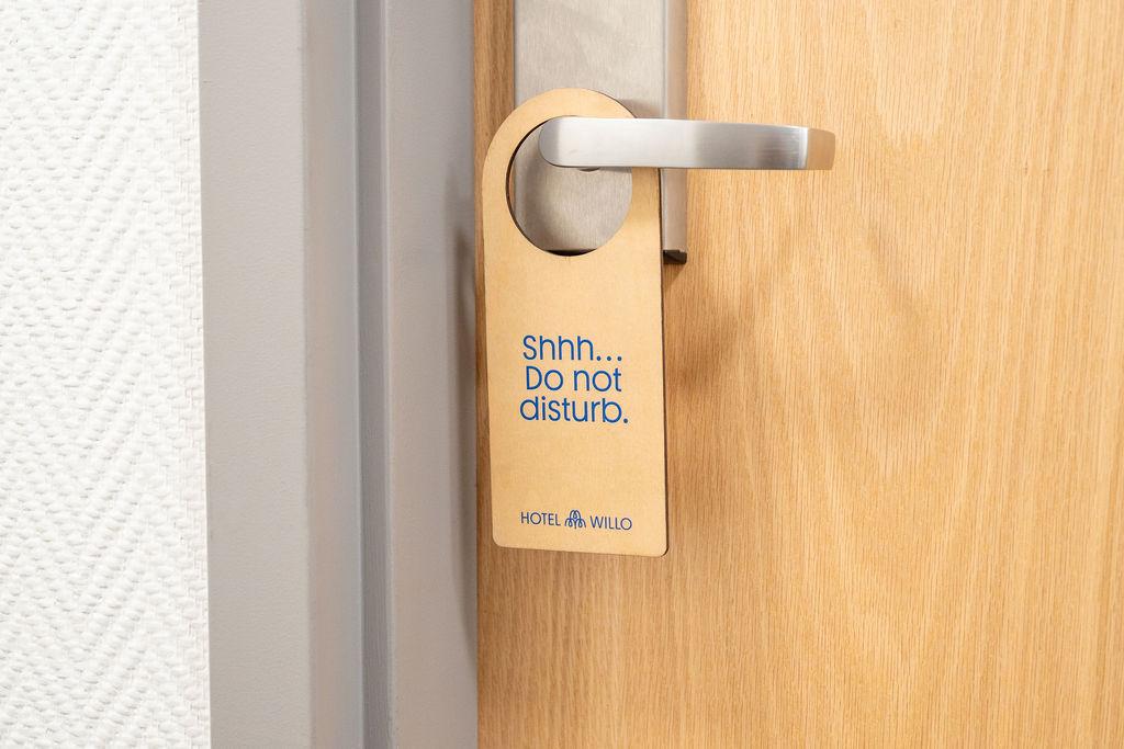 wooden do not disturb sign handing on door handle of Hotel Willo room.