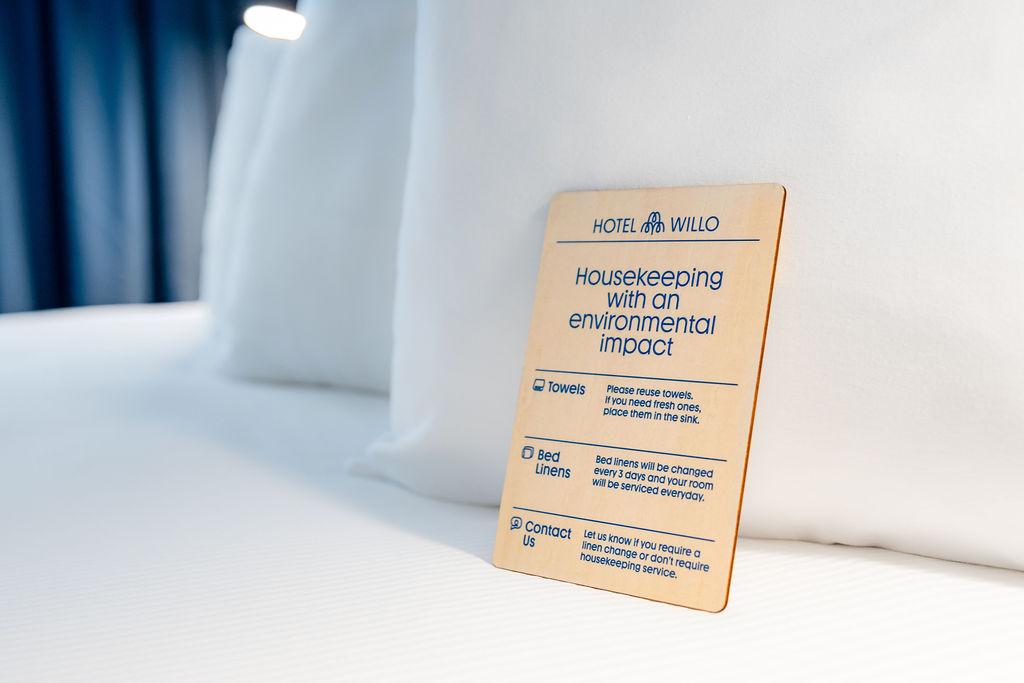 Hotel Willo's wooden housekeeping sign on bed.