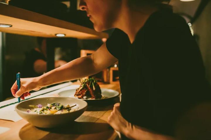 Server prepping food at Burdock and Co