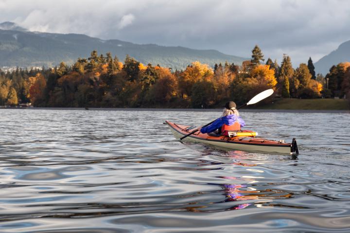 Person kayaking with  the view of Vancouver fall trees